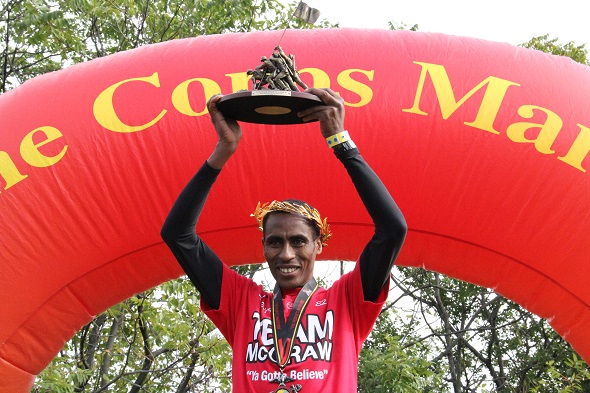 Girma Bedada, 33, a member of the national Ethiopian running team, holds his trophy high Sunday after winning the Marine Corps Marathon in 2:21:32. (Marina Cracchiolo / Medill