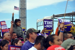 A young protestor waves an American flag in the shadow of the Washington Monument during the rally. (Elena Schneider/MEDILL NEWS SERVICE)