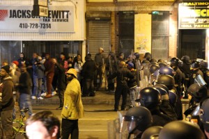 Baltimore police in full riot gear prepare to clear the intersection of Pennsylvania and West North avenues as the curfew approaches. Photo by Matthew Schehl.