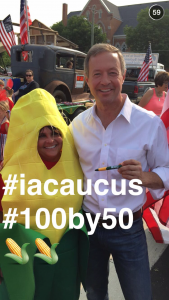 Martin O’Malley poses with a woman dressed as an ear of corn at a parade in Independence, Iowa.