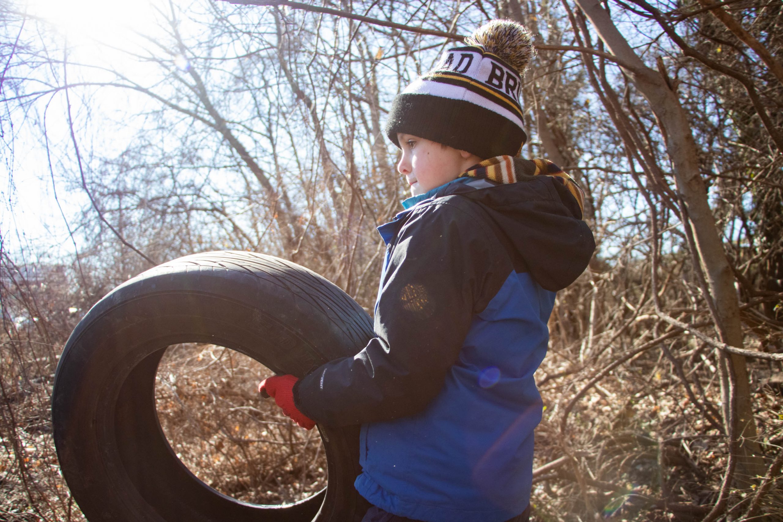 Six-year-old Bill Jack helps move tires that were illegally dumped in Pope Branch Park on Saturday. (Isabel Miller | Medill News Service)