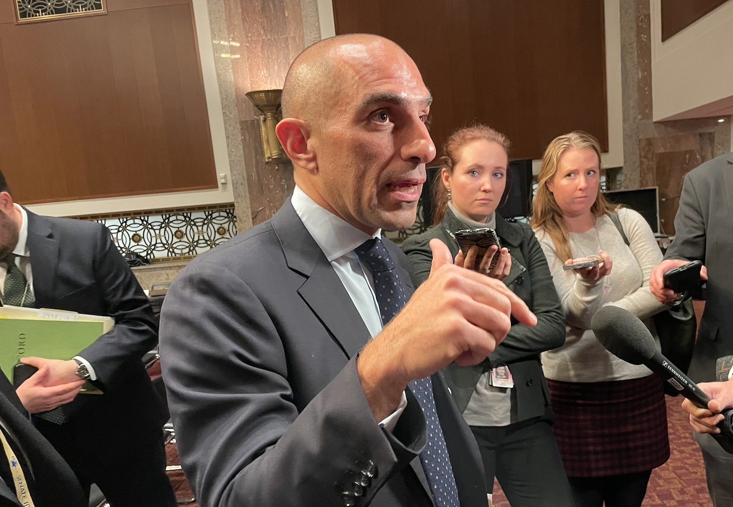 Rostin Behnam, chairman of the Commodities Futures Trading Commission, speaks to reporters Thursday afternoon after a U.S. Senate committee hearing. Two reporters are standing on the right side of the photo.